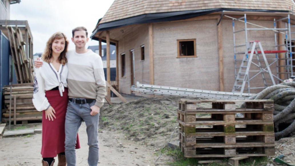 Two people are standing in front of a construction project